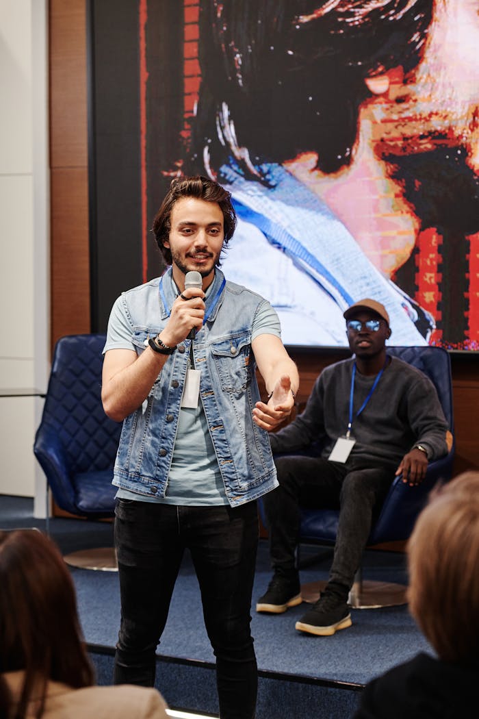 creative-03 Young male speaker engaging audience at a professional conference indoors.